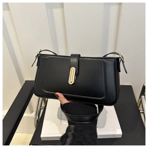 Detailed close-up of the black leather shoulder bag with a gold rectangular metal lock