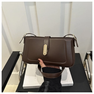 Detail of dark brown matte leather shoulder bag with vintage gold rectangular lock