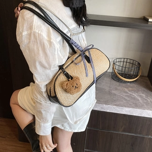 Fashionable woven straw shoulder bag with black leather trim and cute plush bear charm