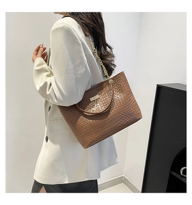 Brown woven tote bag with chain strap shown on model for a modern office look