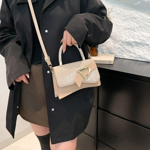 Beige PU leather crossbody bag with sequined flap and golden D-buckle shown on model
