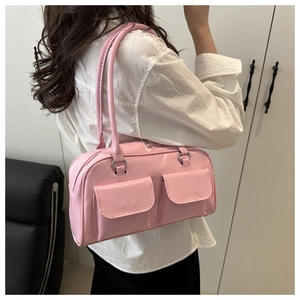 Pink retro bowling bag detail showing dual front flap pockets and glossy leather finish