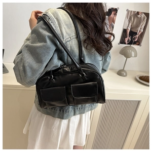 Close-up of black retro tote bag with dual front pockets worn by a model in denim