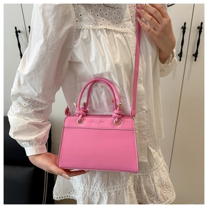 Detailed view of pink casual handbag with gold hardware and fashion trend printed lettering