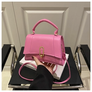 Detailansicht der rosa Ledertasche mit goldenem Oval-Drehverschluss und Tragegriff