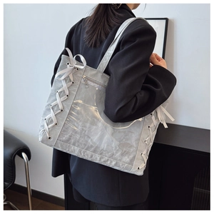 Detail of grey pleated fabric and clear PVC tote bag with white ribbon bow accents