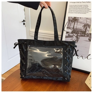 Detail of black tote bag with clear PVC window and cross-ribbon bow side details
