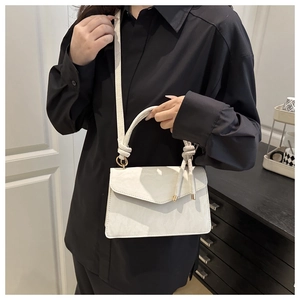Chique beige vierkante handtas met steentextuur getoond op een vrouwelijk model met schouderriem