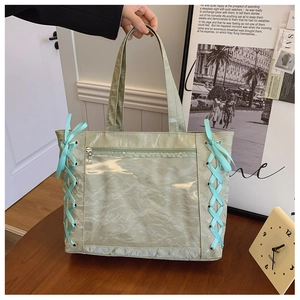 Detail of light green tote bag with transparent window and light blue ribbon accents