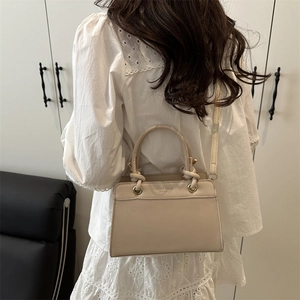 Chic cream white trapezoid handbag with braided handle and fashion trend logo