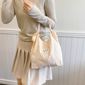Floral canvas tote bag with drawstring closure and soft pink shoulder straps