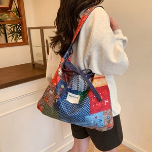 Colorful patchwork canvas tote bag with geometric deer patterns and blue bow detail