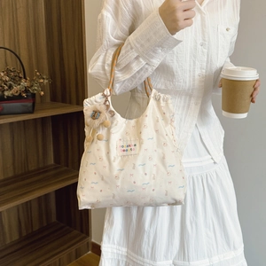 Beige tote bag with cute prints, woven handles and lion plush pendant in casual style