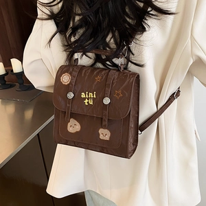 Sac à dos marron en cuir plissé avec broderies cartoon et poignée sur le dessus