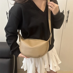 Minimalistische beige Halbmond-Umhängetasche aus mattem PU-Leder am Modell