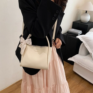 Beige Eimertasche aus Leder mit rosa Karoschleife und abnehmbarem Schultergurt