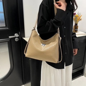 Minimalist woven leather hobo bag in khaki featuring a silver butterfly metallic accent