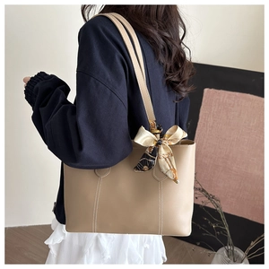 Detail of light khaki tote bag with contrast stitching and vintage patterned silk scarf