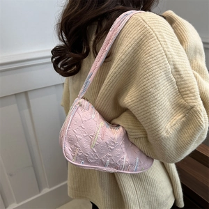 Pink embossed saddle shoulder bag with colorful embroidery and sleek streamlined design