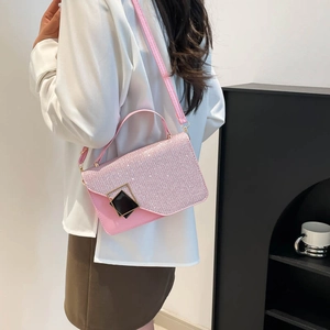 Pink glitter crossbody bag with sparkling rhinestones and adjustable strap on a model