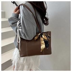 Brown tote bag with white contrast stitching and printed silk scarf on handle