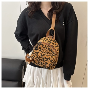 Macro shot of leopard print corduroy backpack with fluffy monster charm and nylon straps