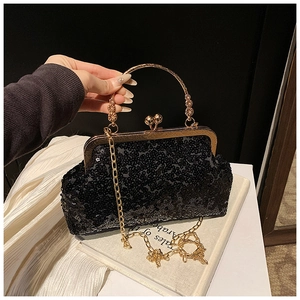 Detail of black sequin evening bag with gold round metal handle and clasp closure