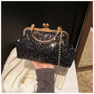 Detail of black sequin evening bag with gold metal handle and chain strap