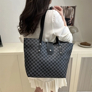 Large commuter tote bag with black and grey M-letter pattern shown on a shoulder model