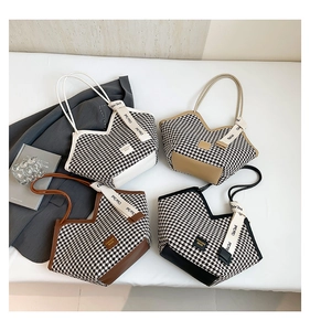 Detail view of houndstooth tote bags with leather labels and branded ribbon straps