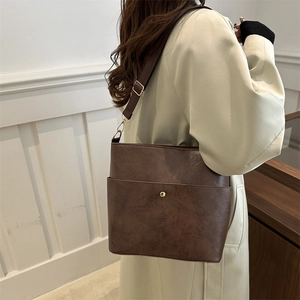 Retro dark brown crossbody bucket bag with gold stud detail and wide shoulder strap