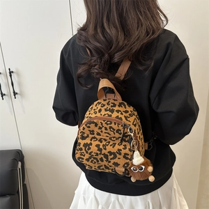 Mini leopard print corduroy backpack with plush charm in a minimalist lifestyle setting
