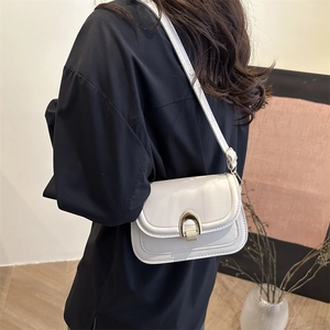 Minimalist white PU leather crossbody bag with golden U-shaped buckle on black background