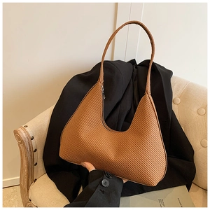 Détail d'un sac hobo marron avec texture gaufrée et bandoulière intégrée élégante