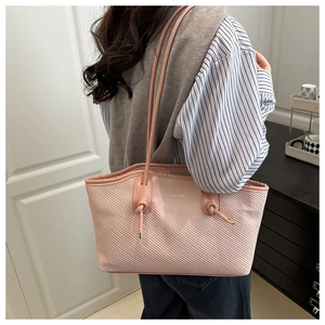 Detail of pink shoulder bag with textured fabric, metal knot buckle and Fashion logo