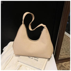 Détail du sac hobo croissant beige avec texture tissée et fermeture éclair en métal