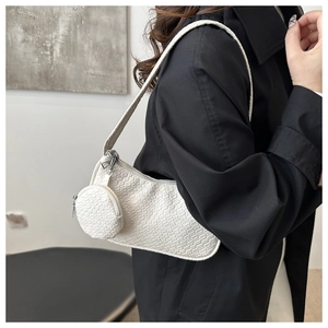Detail of white woven texture shoulder bag with small round coin purse and silver zipper