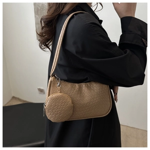 Detail of khaki embossed shoulder bag with detachable coin purse on a black coat