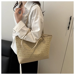 Detalle de un gran bolso de paja con asas de cuero beige para el uso diario de oficina