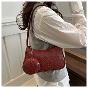 Detail of dark red woven leather shoulder bag with matching round coin purse charm