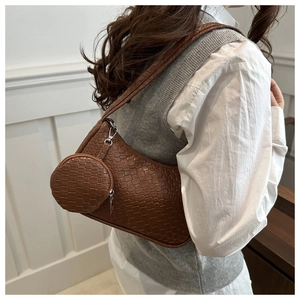Detail of a brown woven texture shoulder bag with a small round matching coin purse