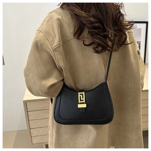 Détail du sac croissant noir avec boucle géométrique dorée de style grecque