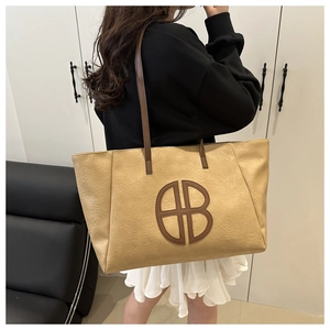 Detailed view of light brown tote bag with natural pleated texture and BB logo