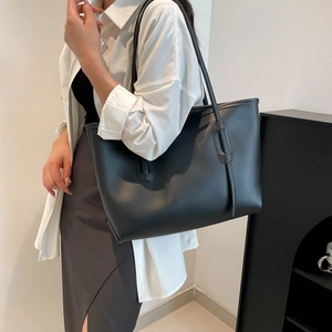 Large black minimalist tote bag in matte faux leather with slim shoulder straps for women