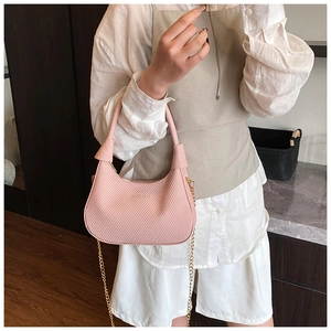Detailansicht der rosa Crescent-Tasche mit Webstruktur und goldener Metallkette