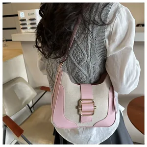 Détail du contraste cuir rose et toile avec grande boucle en métal doré sur le sac à main