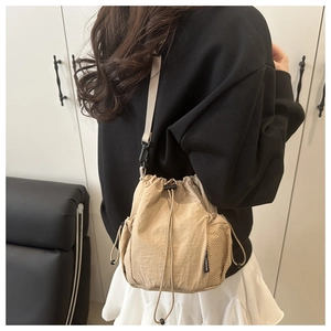 Detail der beigen Nylon-Beuteltasche mit seitlicher Netztasche und Fashion-Label