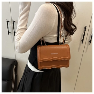 Caramel lychee pattern leather square bag with wave edge and chain strap on model