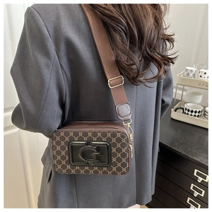 Détail d'un sac bandoulière vintage avec logo G doré et large bandoulière en nylon