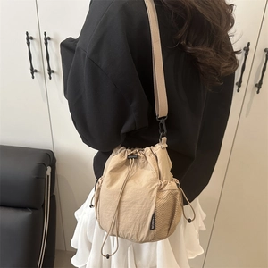 Bolso saco de nailon beige con cordón, bolsillo lateral de malla y correa ajustable